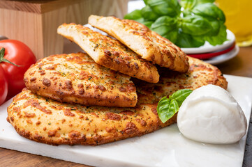 Tasty italian vegetarian food, fresh baked flat foccachia bread with white mozzarella cheese and herbs
