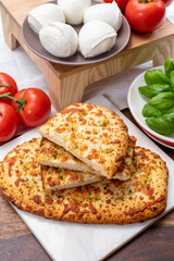 Tasty italian vegetarian food, fresh baked flat foccachia bread with white mozzarella cheese and herbs