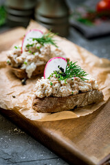 forshmak of herring with black bread , bruschetta with forshmak on dark concrete table