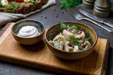 milk mushroom salted on a plate with sour cream on dark concrete table
