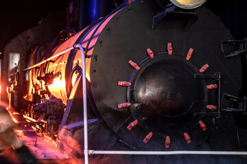 Obraz na płótnie Canvas A brightly lit old steam locomotive. Front view. Selective focus.