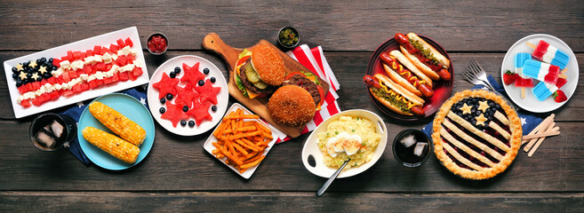 Fourth of July, patriotic, American themed food. Top view table scene on a dark wood banner...