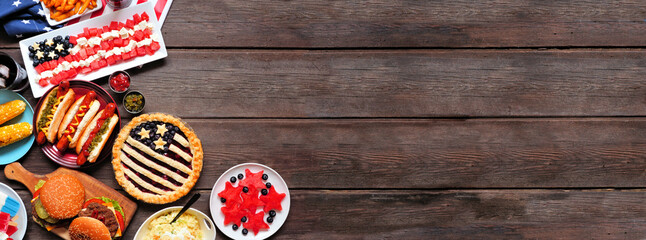 Fourth of July, patriotic, American themed food. Overhead view corner border on a dark wood banner...