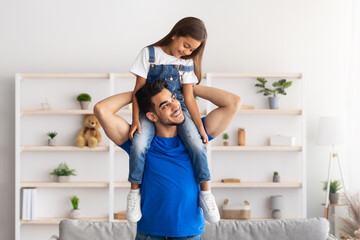Cheerful Man Riding Excited Daughter On His Shoulders