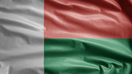 Obraz premium Malagasy flag waving in the wind. Close up Madagascar banner blowing soft silk.