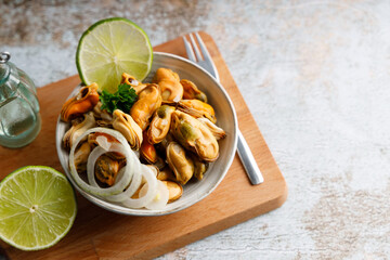 Mussels marinated in vinegar. Seafood appetizer fresh mussels marinated in vinegar and onions in a bowl. Top down view.