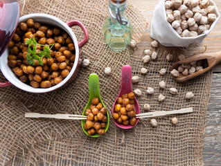 Fototapeta na wymiar Vegan grilled chickpeas. Homemade vegan chickpeas, Crispy roasted organic chickpeas . Served as a snack in a bowl, on a wooden table top.