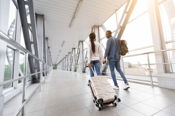 Travelling Together. Romantic African American Couple With Luggage Walking In Airport Terminal