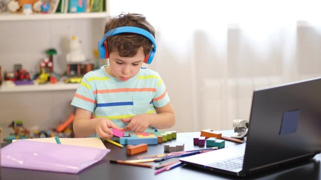 boy doing logic exercises at home communicating with the teacher via video communication