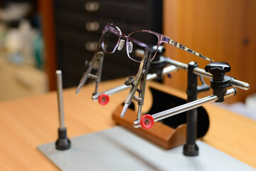 Pair of glasses attached on the hand soldering iron stand stock photo.