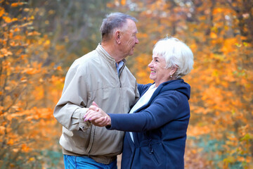 Two seniors dancing in an autumn square
