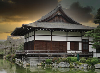 a japanese house in a pond at sunset