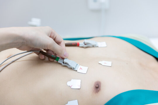 Heart electrocardiogram or monitoring using Holter for young patient. Male athlete does a cardiac stress test. wearing Holter monitor device for daily monitoring of an electrocardiogram. 