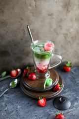 Strawberry matcha latte in a transparent double glass cup. Cold drink. Healthy eating. Raw cuisine.