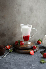 Strawberry matcha latte in a transparent double glass cup. Cold drink. Healthy eating. Raw cuisine.