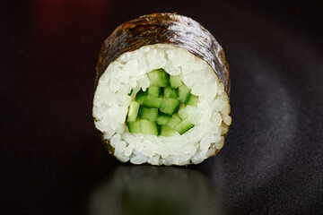 sushi with cucumber and rice one piece close up black background