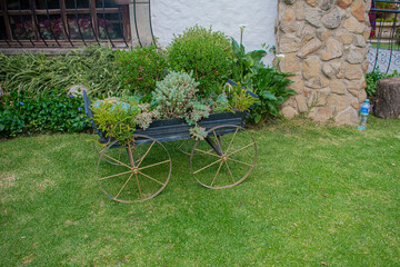 carreta de metal con flores verdes