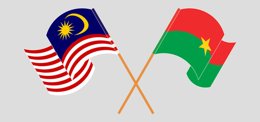 Crossed and waving flags of Malaysia and Burkina Faso