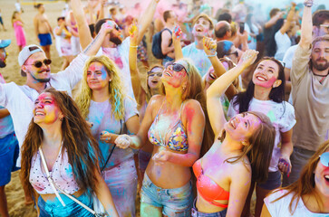 A group of friends have fun,  dance at the holi festival. Spring Break Beach Party. Celebrating traditional indian spring holiday. Friendship, Leisure, Vacation, Togetherness.