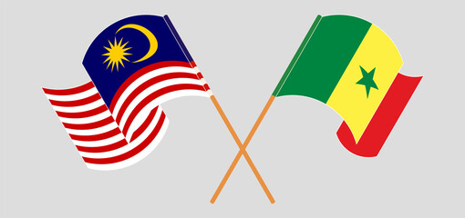 Crossed and waving flags of Malaysia and Senegal