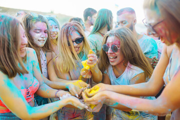 A group of friends have fun,  dance at the holi festival. Spring Break Beach Party. Celebrating...