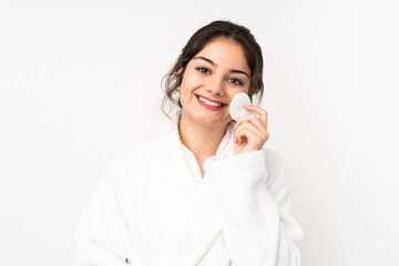 Young caucasian woman isolated on white background with cotton pad for removing makeup from her face
