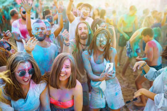 A group of friends have fun,  dance at the holi festival. Spring Break Beach Party. Celebrating traditional indian spring holiday. Friendship, Leisure, Vacation, Togetherness.