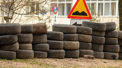folded old car tires lie on the ground near the road, background