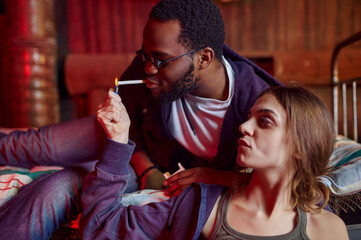 Drug addicts smokes a cigarette while high in den