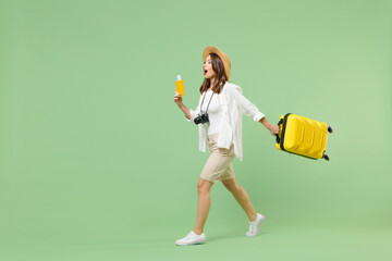 Full length side view traveler tourist woman in casual clothes hat hold suitcase passport ticket...