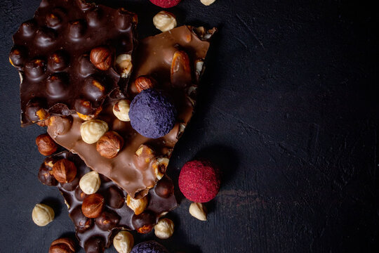 Chocolate bar, crushed pieces of dark chocolate and nuts. Praline Chocolate sweets. Copy space © volody10