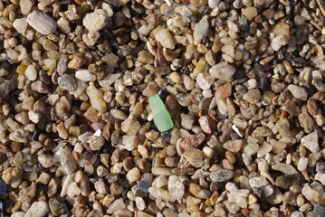 grains of sand and green polished glass