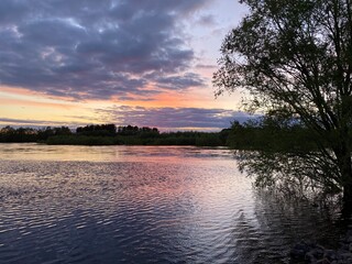 Beautiful sunset, sky, illuminated orange clouds, sunset on the river