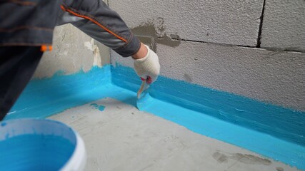 Cover the concrete wall with a cement-polymer waterproofing membrane. Waterproofing with a blue...
