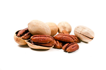 Heap of whole and cracked pecan nuts isolated on a white background.
