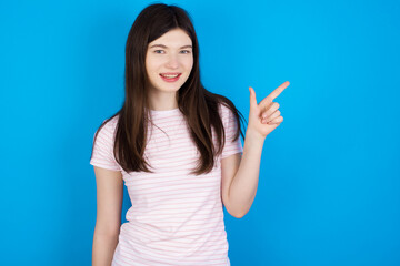 young beautiful Caucasian woman wearing stripped T-shirt over blue wall pointing up with fingers number eight in Chinese sign language BĀ.