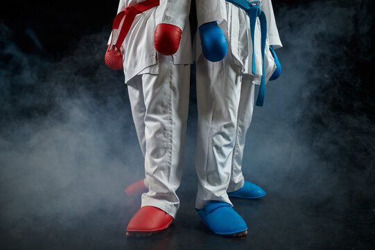 Two karatekas poses in white kimono and gloves