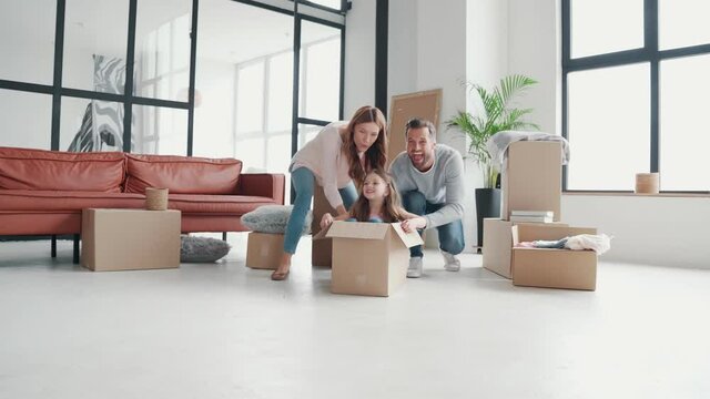 Playful young family having fun together while moving into a new apartment 