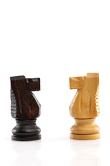 Two chess horses are standing next to each other, isolated on a white background. Close-up.