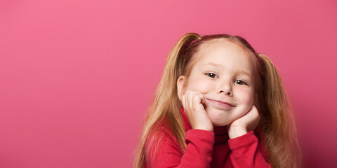 Portrait of a cute smiling 6 years old girl Isolated over pink background