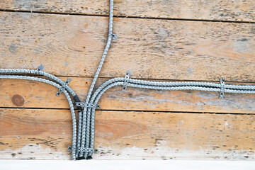 Aluminum tubing for wire protection lined up on old concrete wall .