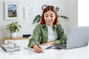 Woman remotely working at home with laptop computer. Young businesswoman planning her time. Concept...