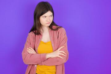 Displeased young beautiful Caucasian woman wearing casual clothes over purple wall with bad...