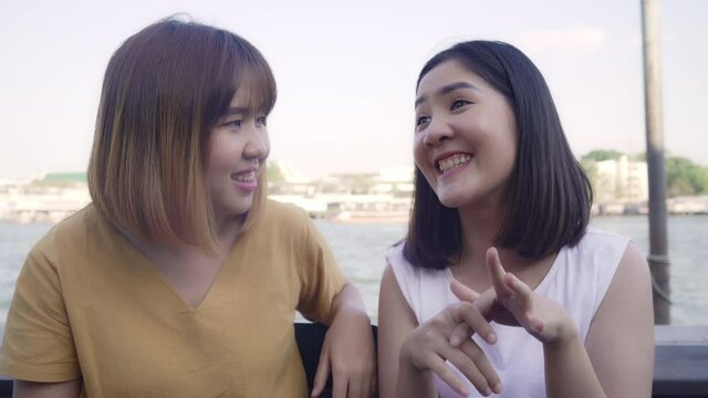 Young Asian women close friend tourist with casual enjoy talking gossip chat in front of port boat on the river feel happy joyful travel at cafe city town, Lifestyle tourist travel holiday concept.