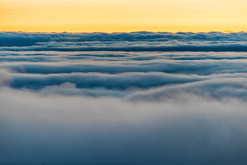 High angle aerial view above inversion clouds cloudscape at sunrise morning in Wintergreen Resort,...
