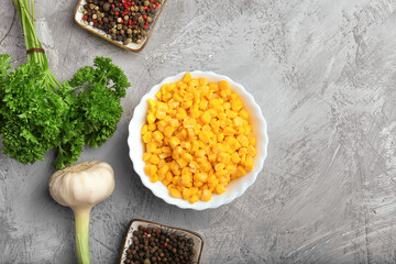 Tinned corn in a white plate on a stone background