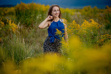 A brunette woman girl in the middle of a blooming field. Pollen and bloom allergies.