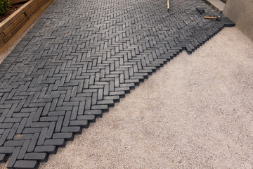 Paving stone driveway installation, 90 degree pattern laid by hand.