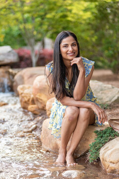 Beautiful Asian Indian woman sitting by a small creek