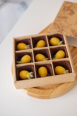 chocolate in the shape of yellow pineapples are in a box; handmade chocolate in the shape of a pineapple; handmade chocolate in a box